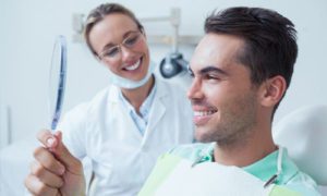 man admiring teeth - New Patient Info on Dental Insurance
